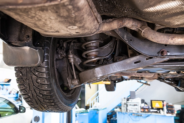Underside of vehicle showing suspension shock behind wheel
